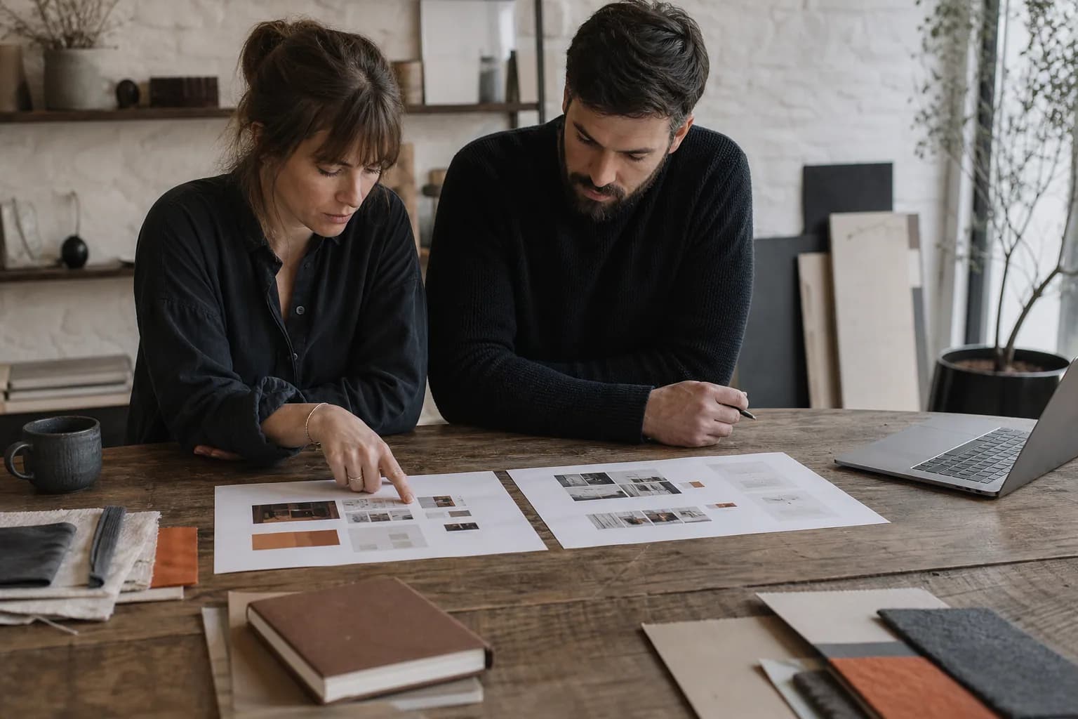 Old and new website layouts being compared on a designer's desk